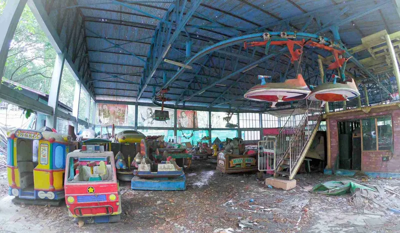 Zona cubierta del parque abandonado, con un mural descolorido al fondo