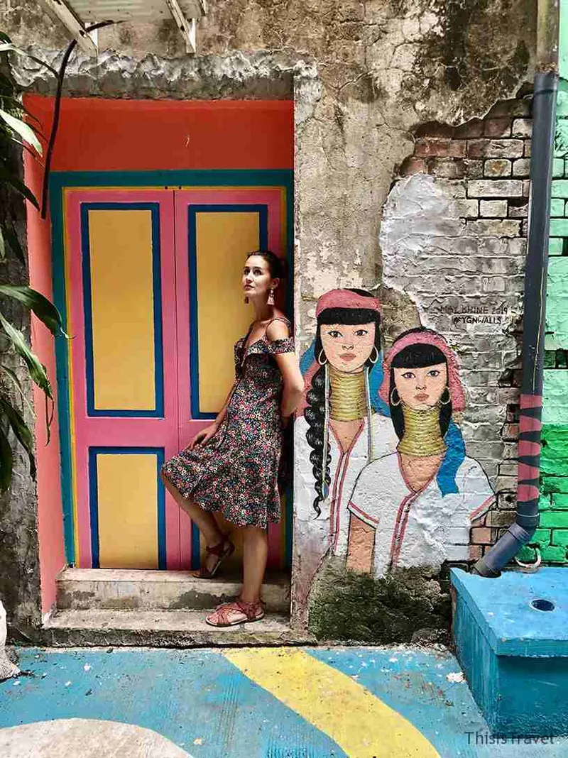 Puerta pintada de colores con dos mujeres birmanas dibujadas al lado