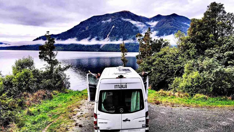 Campervan aparcada junto al lago de Nelson Lakes, con las montañas detrás