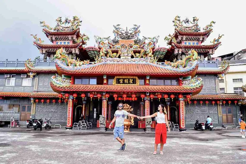 Templo taiwanés de tejados curvos con gente en la entrada