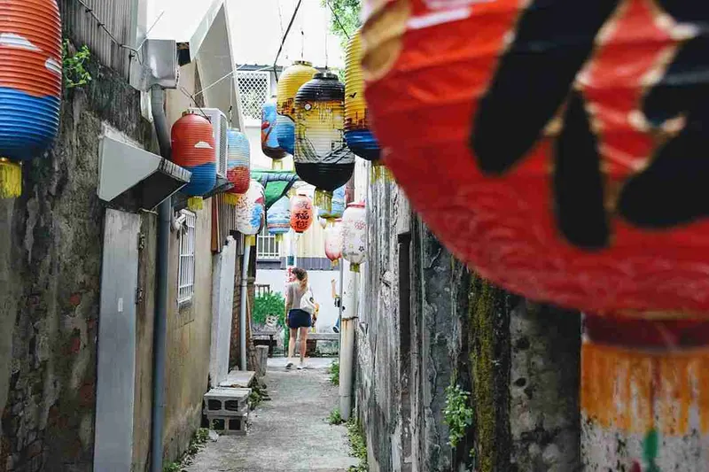 Callejón estrecho decorado con farolillos de colores