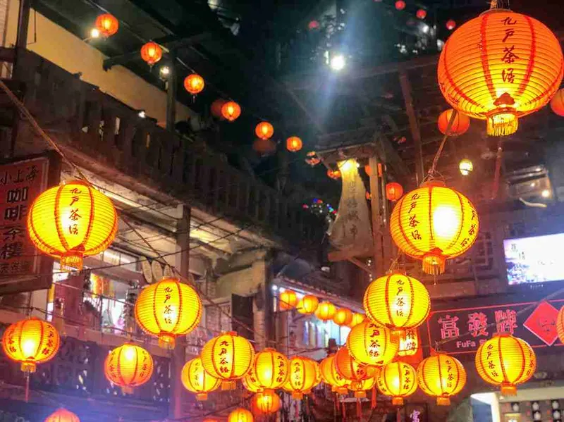 Calle de Jiufen cubierta de farolillos rojos encendidos de noche