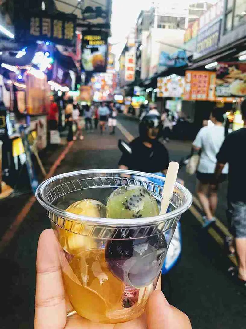 Vaso de té con perlas en un mercado nocturno