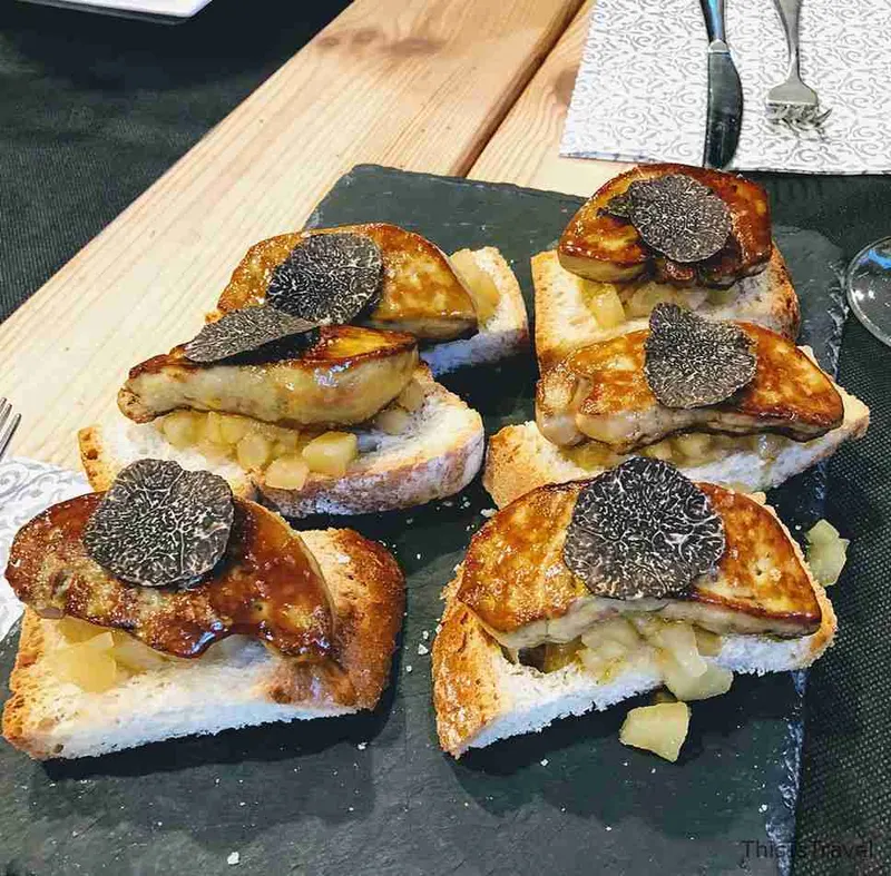 Tostas con trufa negra rallada por encima