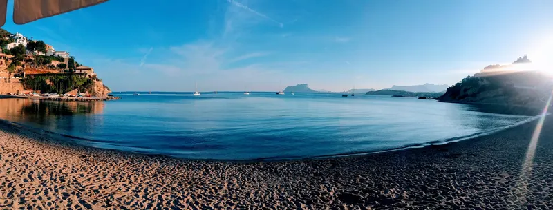 Playa de Moraira a última hora de la tarde, con la costa al fondo