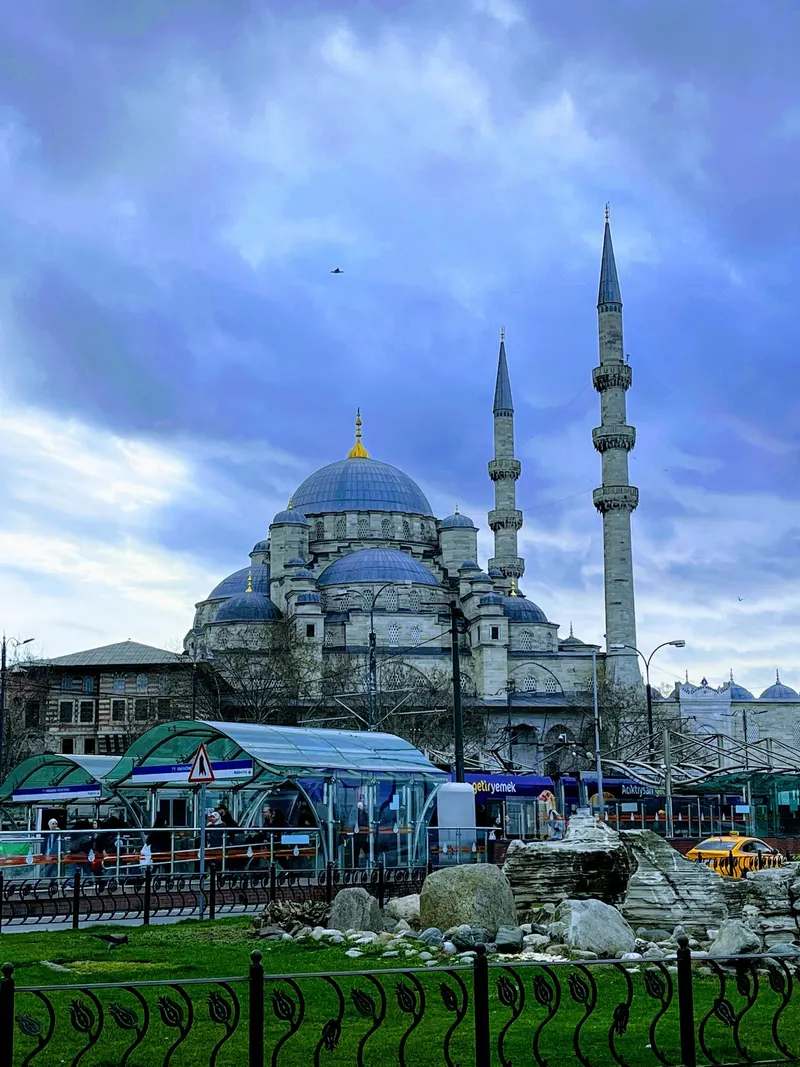 La mezquita Nueva de Eminönü, en Estambul, con la parada del tranvía y un taxi amarillo delante
